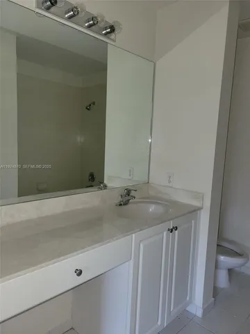 a bathroom with a granite countertop sink and mirror