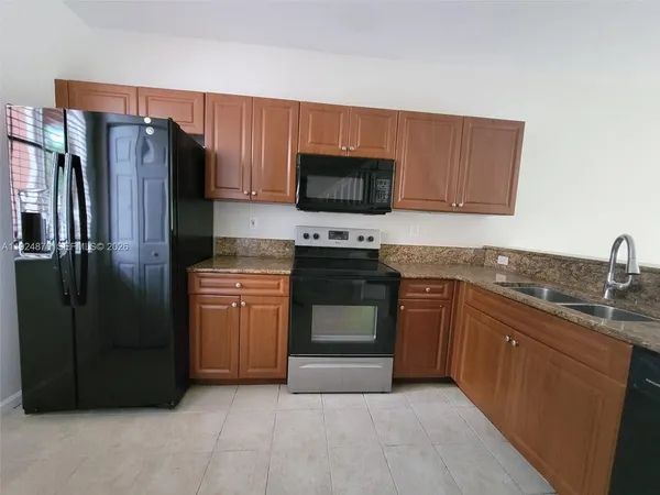 a kitchen with stainless steel appliances granite countertop a refrigerator stove a sink and dishwasher