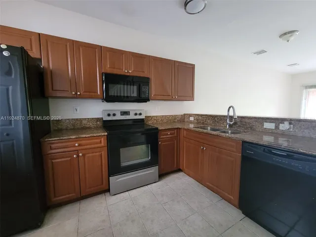 a kitchen with granite countertop wooden cabinets and a stove top oven