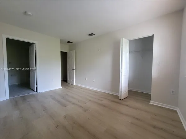an empty room with closet and a bathroom
