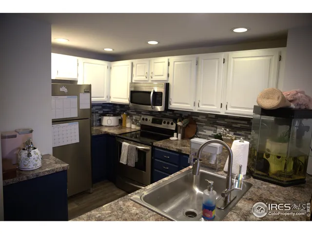 a kitchen with stainless steel appliances kitchen island granite countertop a stove a sink and a microwave
