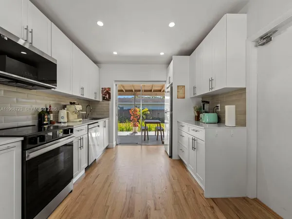 a kitchen with stainless steel appliances granite countertop a stove top oven a sink and a microwave