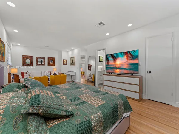 a bedroom with a bed and wooden floor