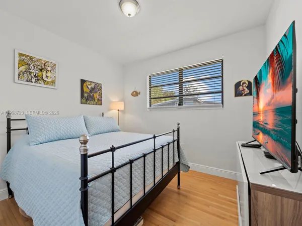 a bedroom with a bed and a large window