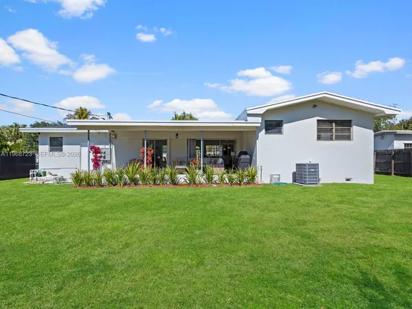 a view of a porch with a table and chairs under an umbrella