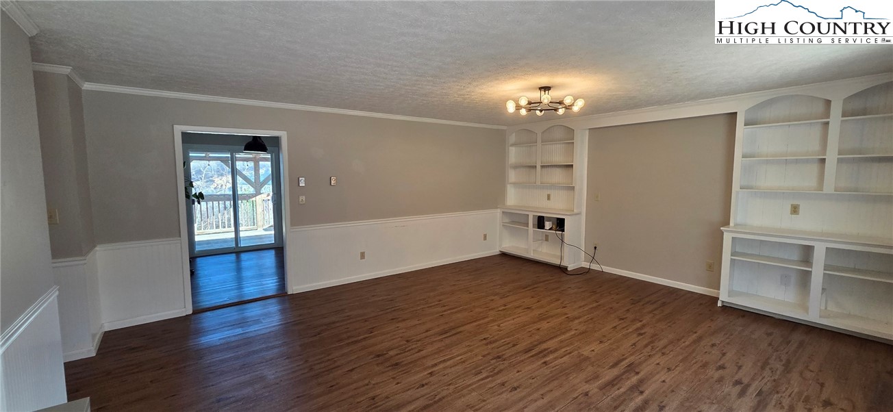 516 White Laurel Lane Boone, NC 28607 - Photo 14 of 27 an empty room with wooden floor chandelier and windows