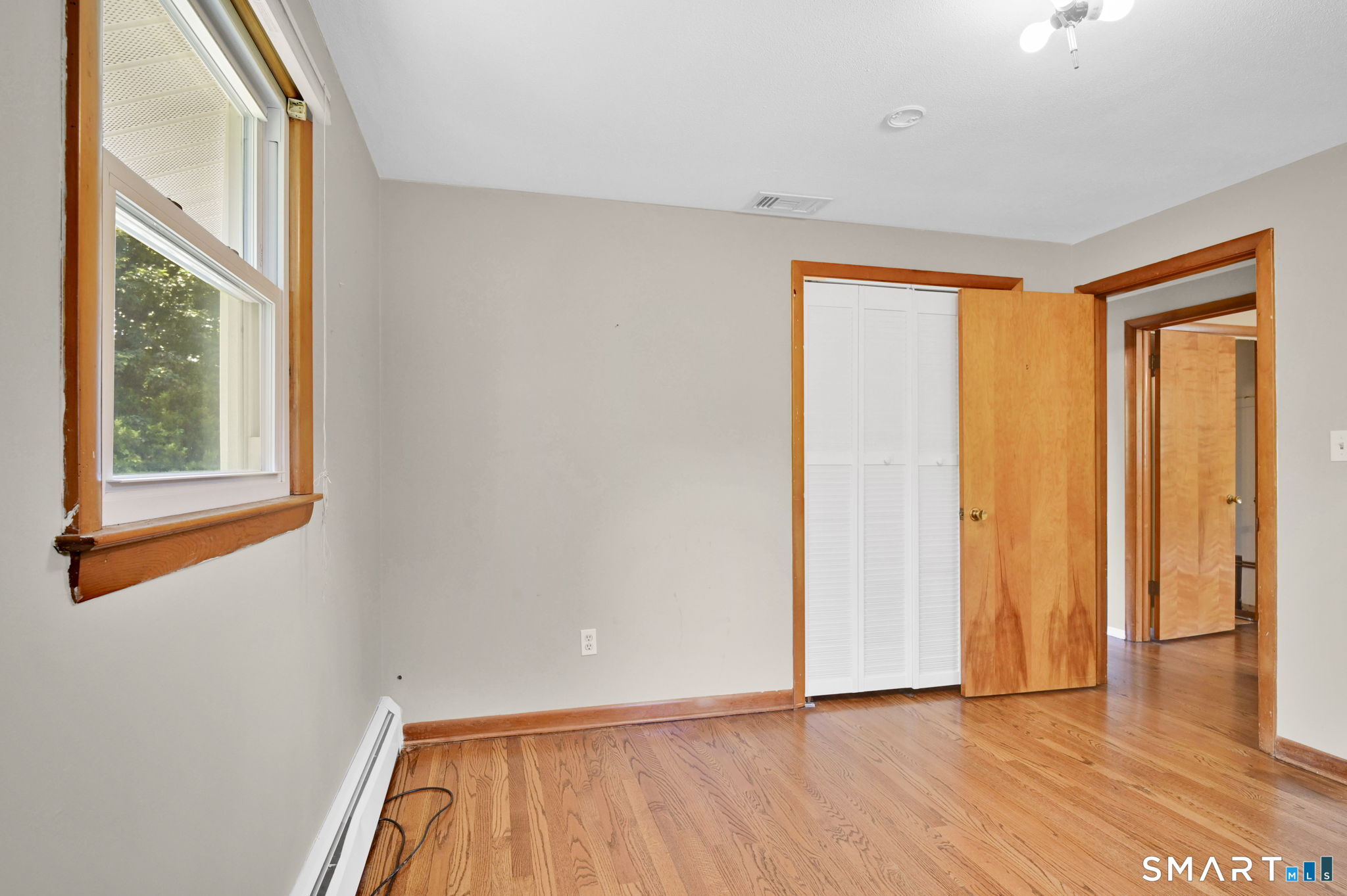 7 Rogers Drive Meriden, CT 06450 - Photo 23 of 40 a view of an empty room with wooden floor and a window