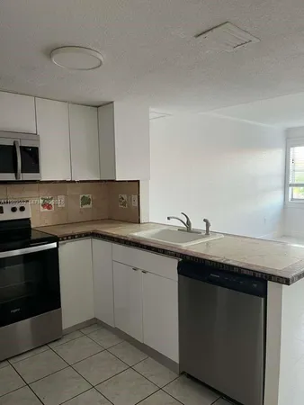a kitchen with stainless steel appliances granite countertop a sink and a stove