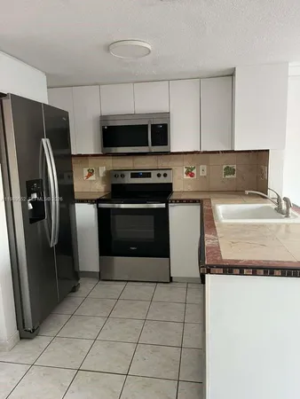 a kitchen with stainless steel appliances granite countertop a refrigerator and a stove