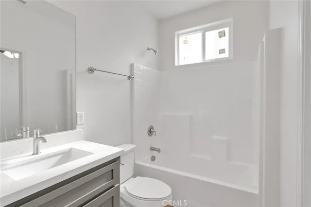 a bathroom with a granite countertop sink toilet a mirror and shower