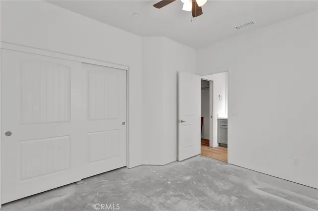 an empty room with chandelier fan