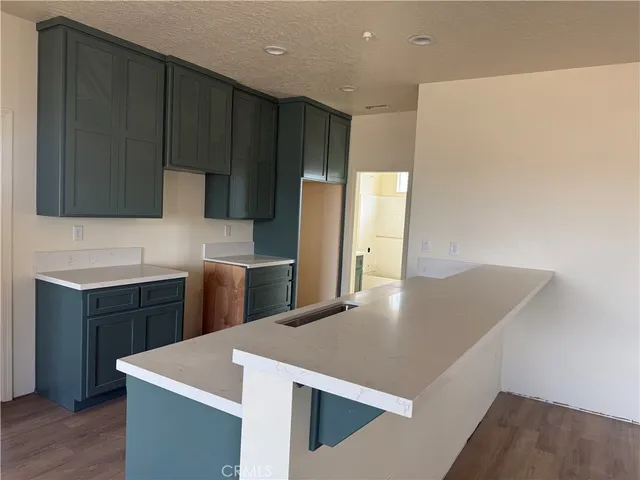 a kitchen with stainless steel appliances a refrigerator a sink a stove a microwave and wooden cabinets