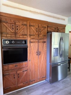 103 Gilkeson Road Honea Path, SC 29654 - Photo 8 of 25 This kitchen showcases ample custom wooden cabinetry, a built-in oven, and a stainless steel refrigerator.