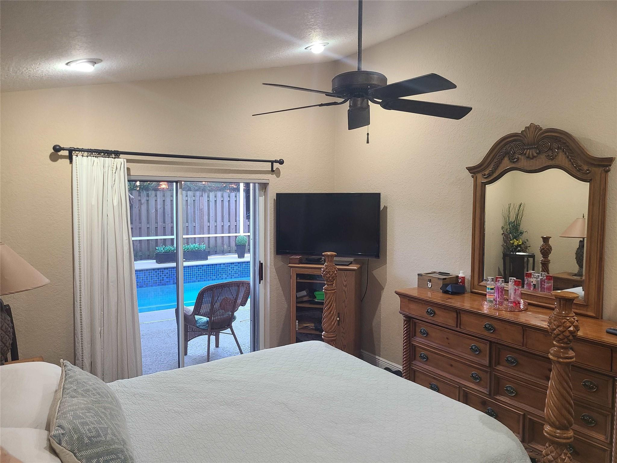 Undisclosed Address Lake Worth, FL 33467 - Photo 13 of 21 a bedroom with a bed and a flat tv screen on dresser