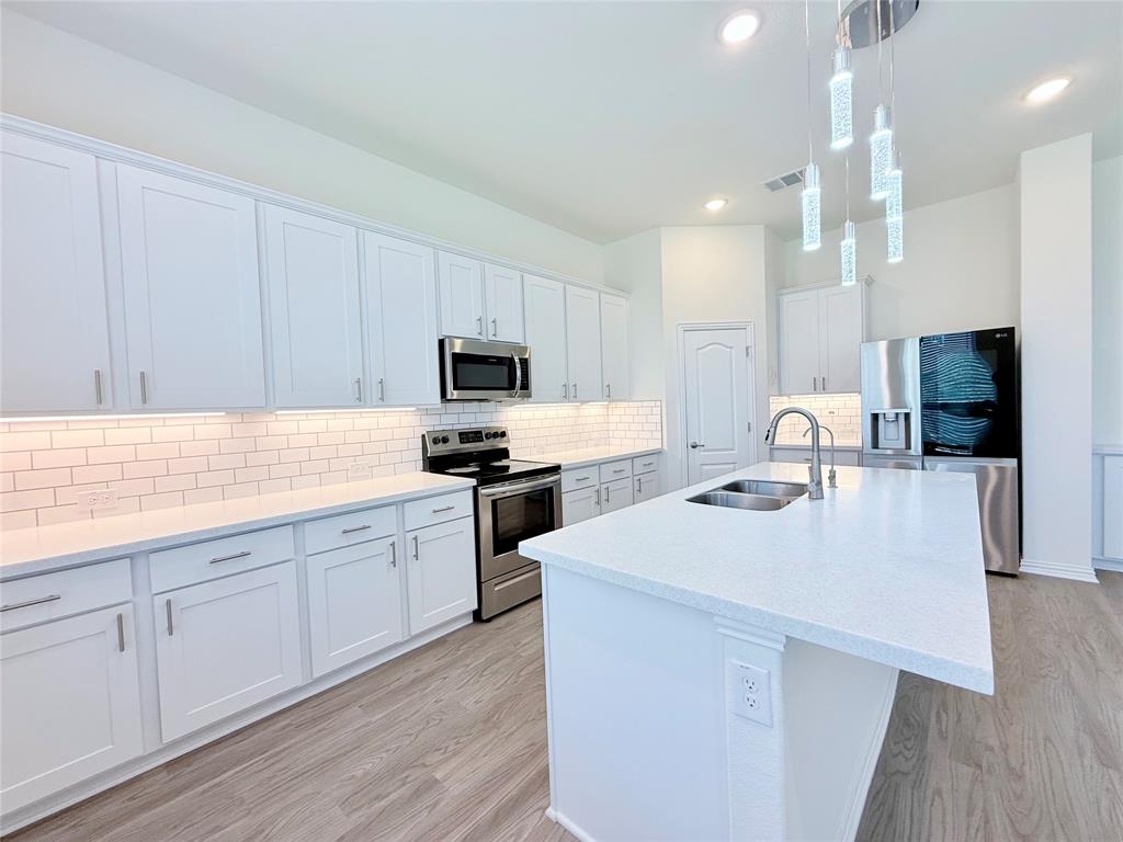 1336 Morning View Road Georgetown, TX 78628 - Photo 13 of 40 A well-appointed culinary space featuring sleek cabinetry, quartz countertops, and modern stainless steel appliances.