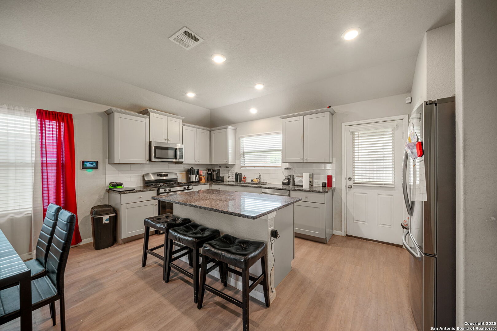 31646 Untrodden Way Bulverde, TX 78163 - Photo 16 of 36 a kitchen with a sink a stove a refrigerator and chairs