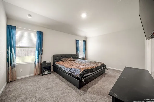 a spacious bedroom with a bed and window