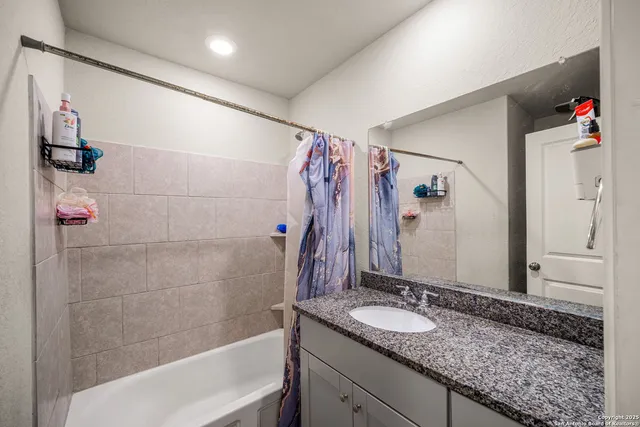a bathroom with a granite countertop sink a shower and a mirror