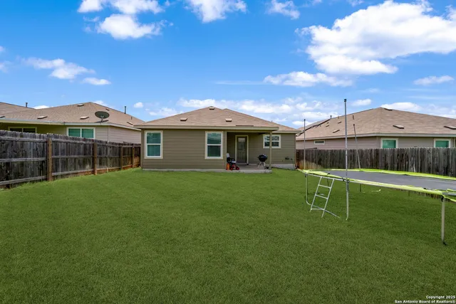 a backyard of a house with table and chairs