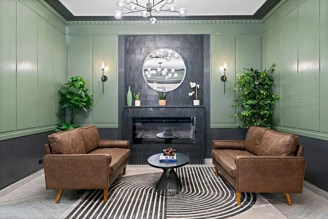 a living room with furniture a clock and a potted plant