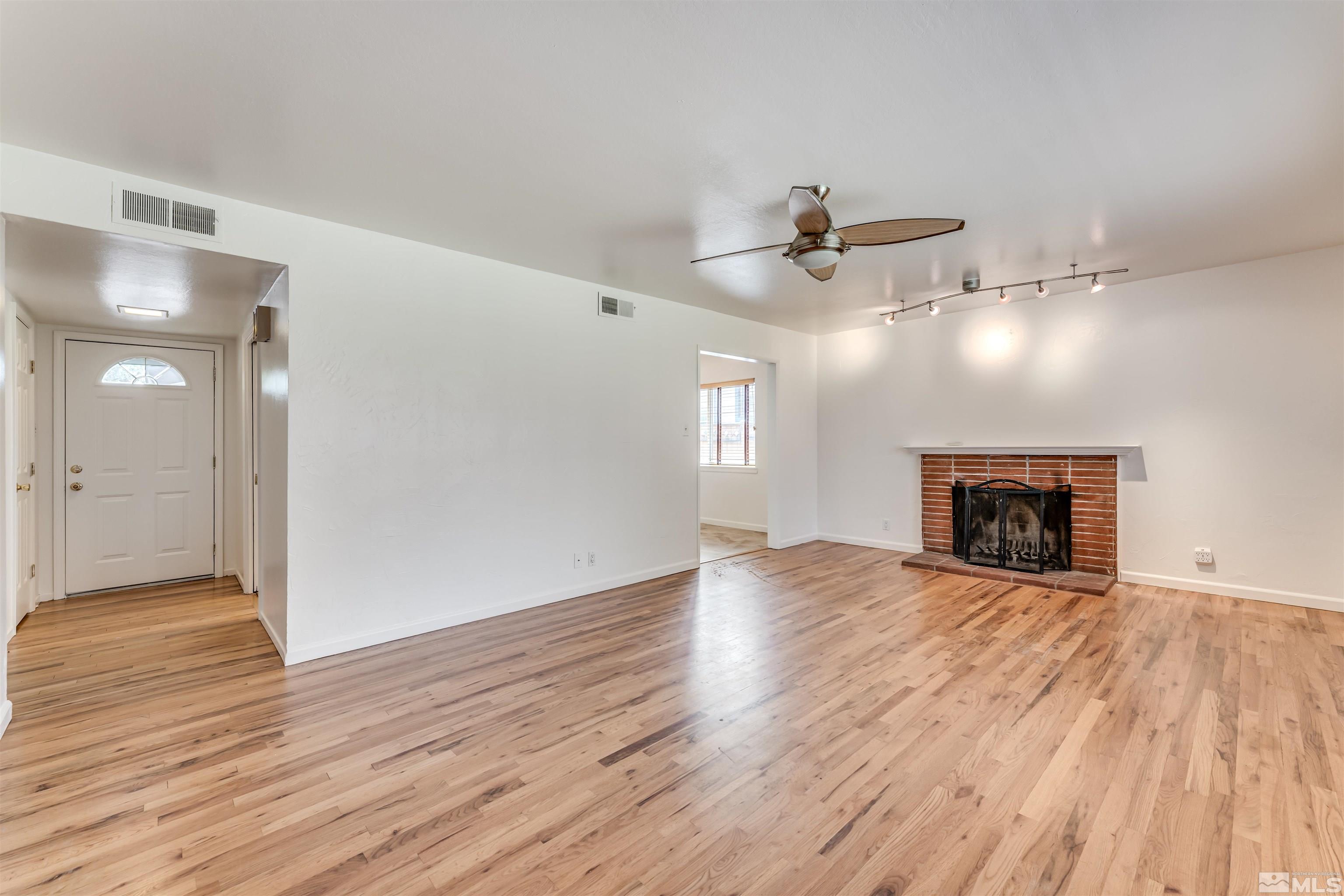 1945 Arcane Avenue Reno, NV 89503 - Photo 7 of 30 a view of an empty room with wooden floor fireplace and a window