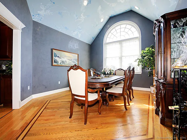 a dining room with furniture a large window and wooden floor