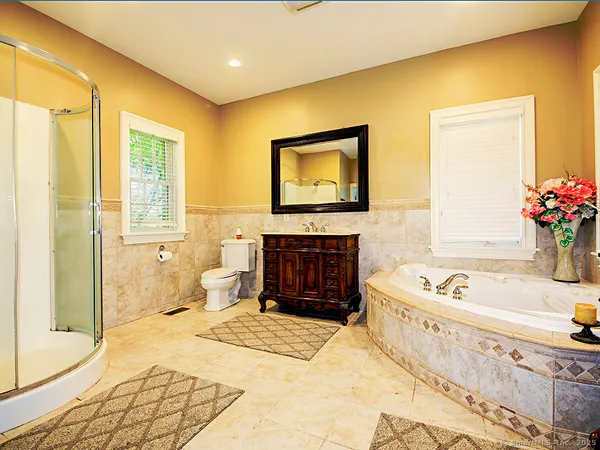 a spacious bathroom with a tub a sink and a mirror