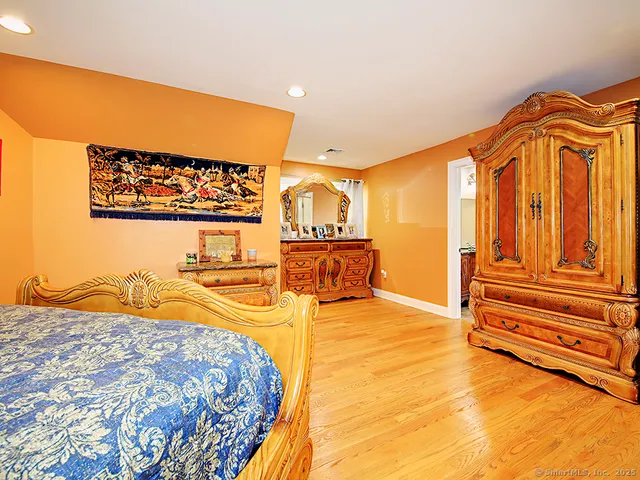 a bedroom with a bed and painting on the wall