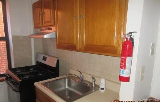 a kitchen with granite countertop a sink stainless steel appliances and cabinets