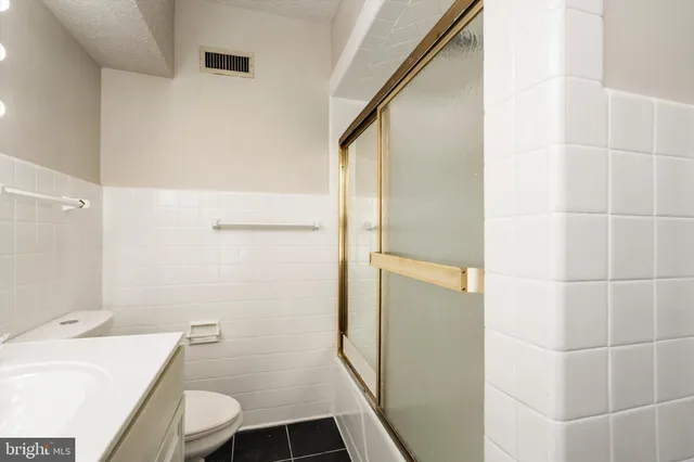 a kitchen with a refrigerator and white cabinets
