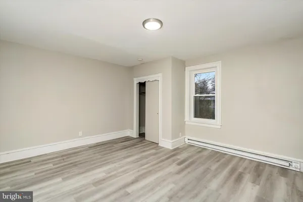 an empty room with a window and wooden floor