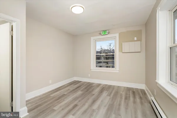 a view of kitchen with stainless steel appliances wooden floor and window