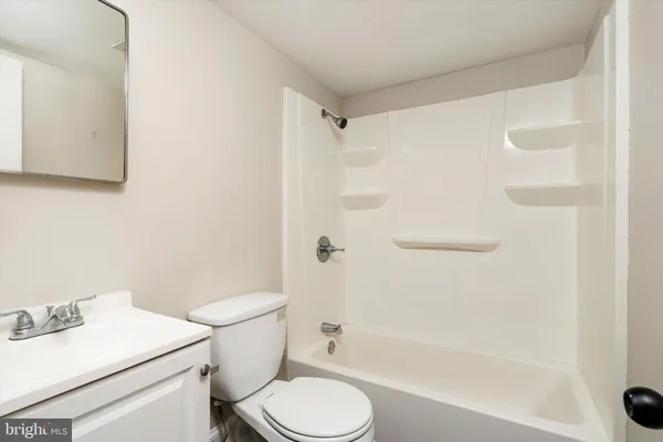 a white toilet sitting next to a bath tub