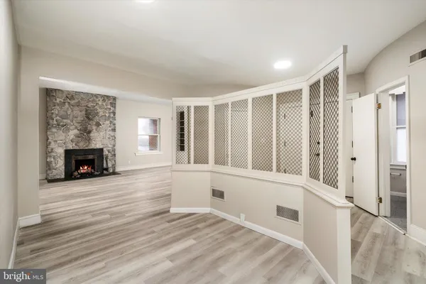 a view of an empty room with a fireplace and a window