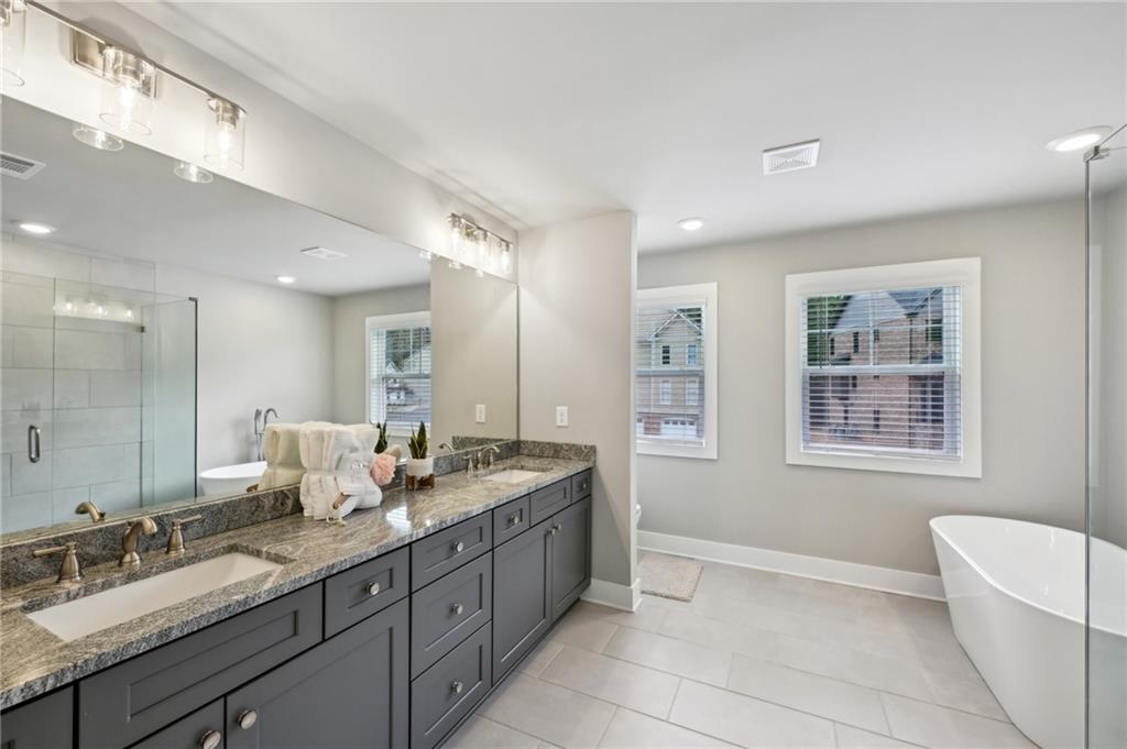 3143 Stonegate Drive Atlanta, GA 30331 - Photo 20 of 32 a spacious bathroom with a granite countertop double vanity sink a mirror and a bathtub