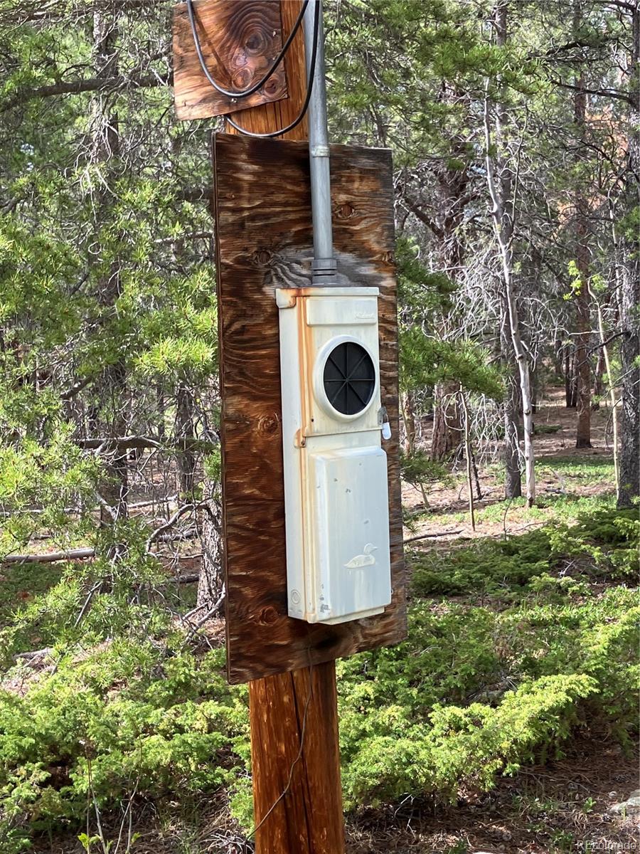 119 Cedar Way Black Hawk, CO 80422 - Photo 9 of 31 a backyard of a house with barbeque oven table and chairs