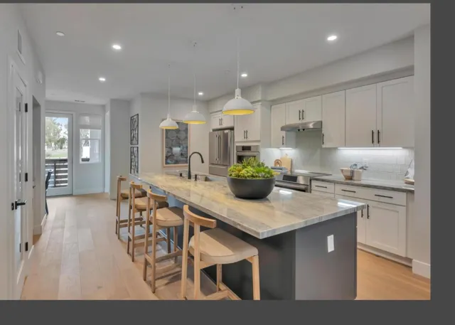 a kitchen with granite countertop a table chairs sink and cabinets