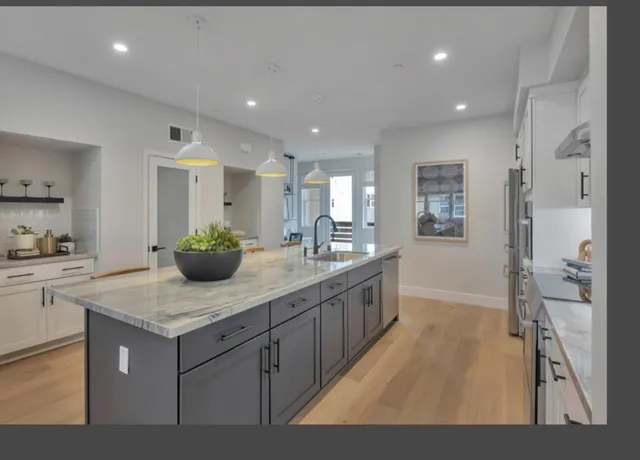 a kitchen with sink cabinets and living room