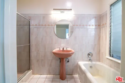 a bathroom with a sink a mirror and a shower