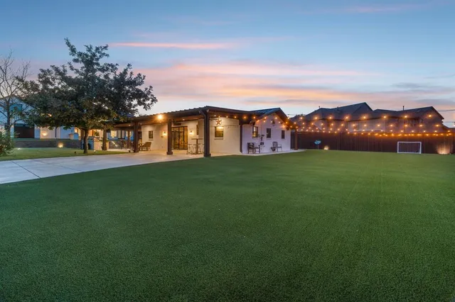 a view of a field with cars parked in front of house