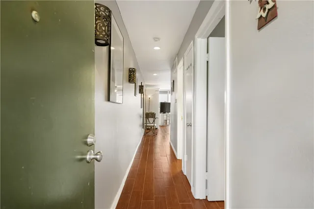 a view of a hallway with wooden floor and staircase