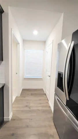 a view of a hallway with wooden floor and staircase