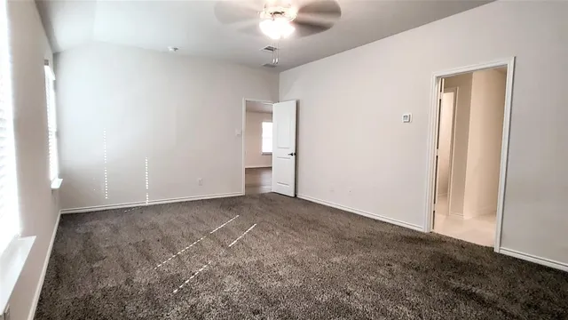 an empty room with fan and entrance