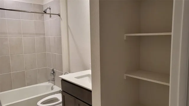 a bathroom with a granite countertop sink and a bathtub