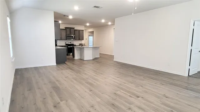 a view of kitchen view wooden floor and stainless steel appliances
