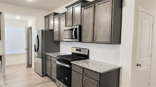 a kitchen with stainless steel appliances granite countertop a refrigerator and a sink