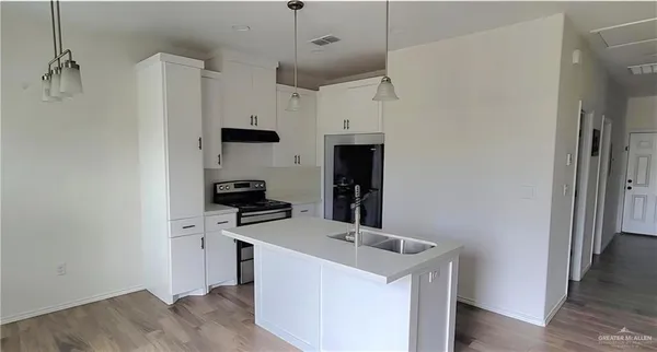 a kitchen with stainless steel appliances a refrigerator and a stove top oven