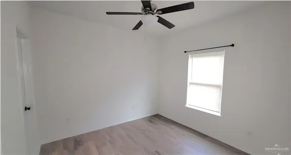 a view of a room with a window and a ceiling fan
