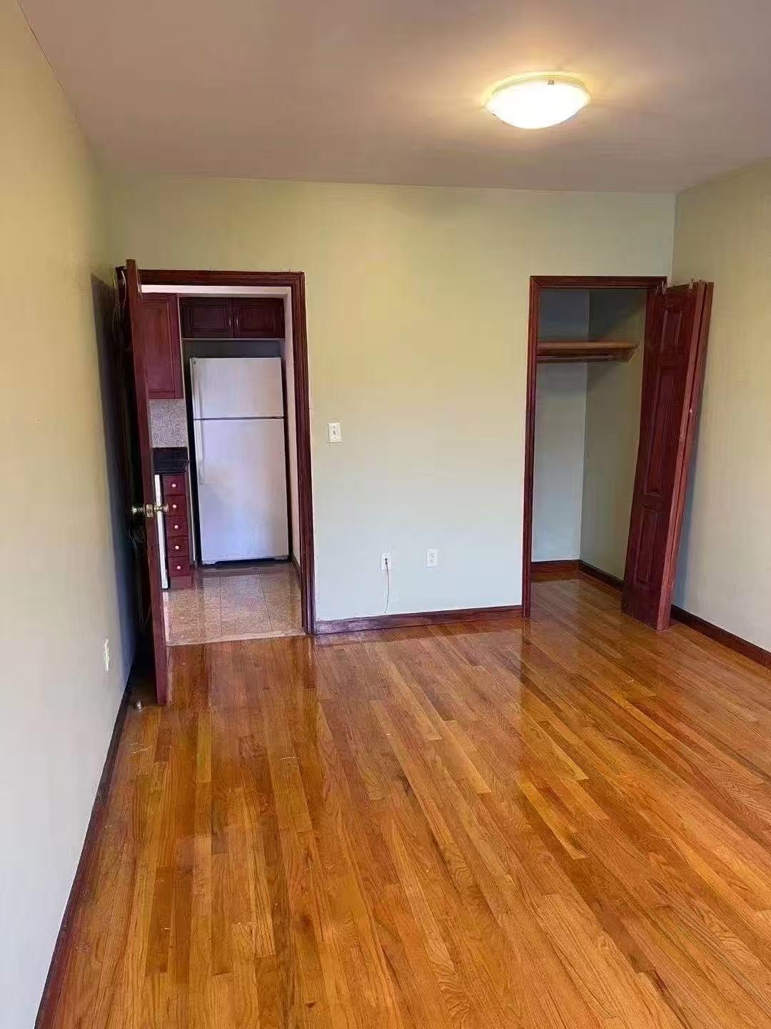 88-27 53rd Avenue, Unit 2R Queens, NY 11373 - Photo 6 of 6 Unfurnished bedroom with freestanding refrigerator, wood finished floors, and a closet