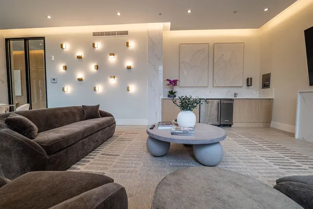 a living room with furniture and a dining table with kitchen view
